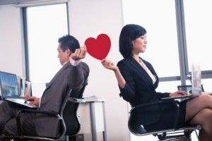 Work romance between two business people holding a heart