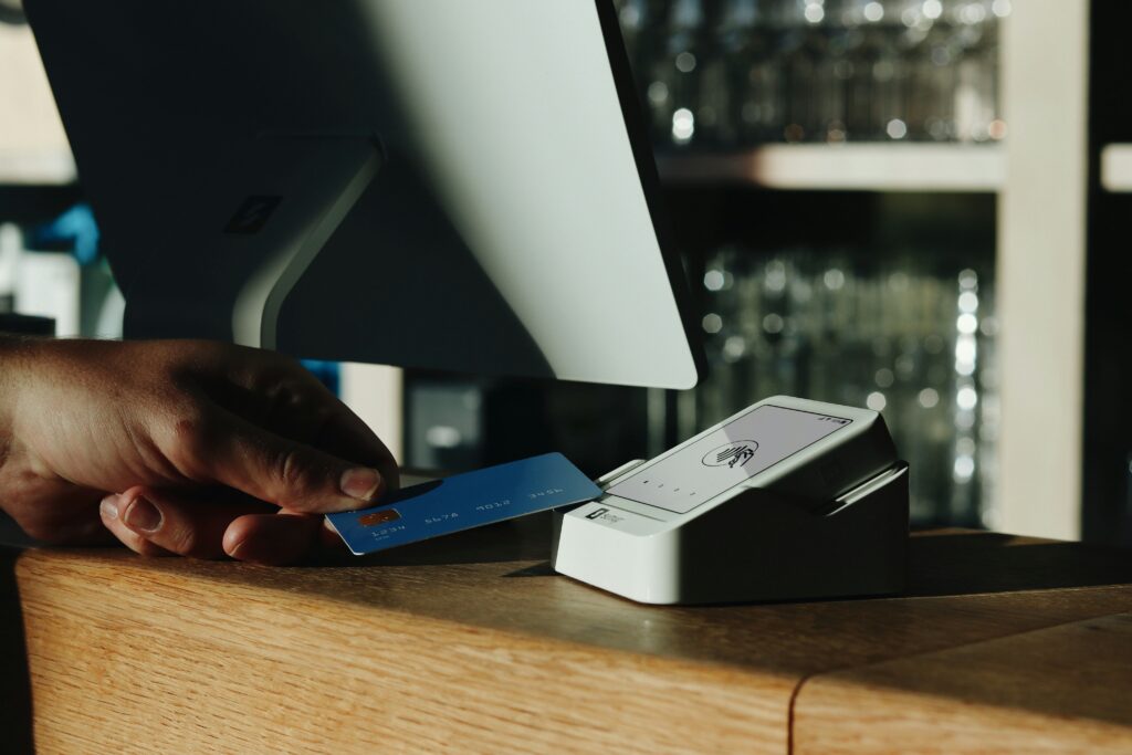 Person using credit card at payment terminal — how scammers use Apple gift cards in fraud schemes