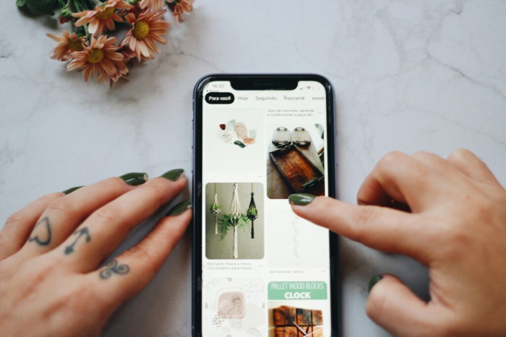 A person browsing a shopping app on their smartphone, representing how to search Poshmark for items and sellers and verify anyone on the platform before buying.