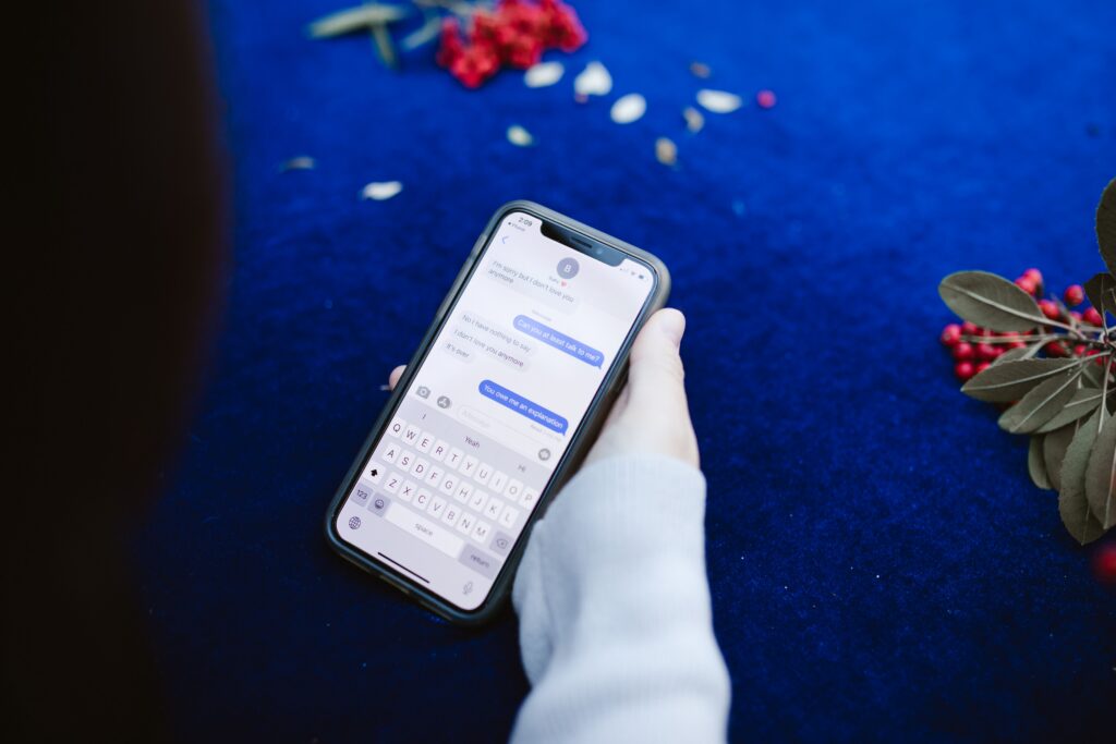 Person holding iPhone checking iMessage conversation to see if they have been blocked