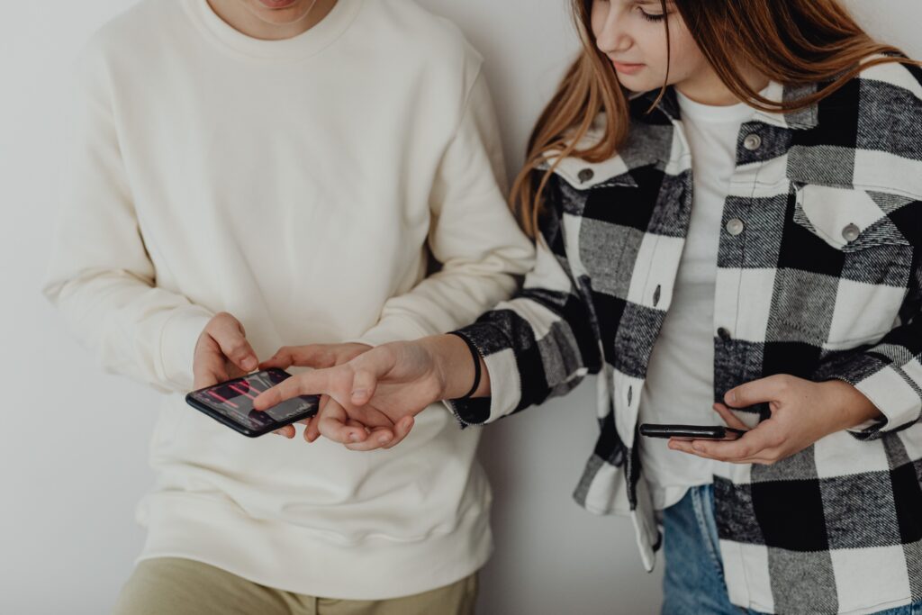 Two people looking at phone together — how to check if your girlfriend has a secret OnlyFans account