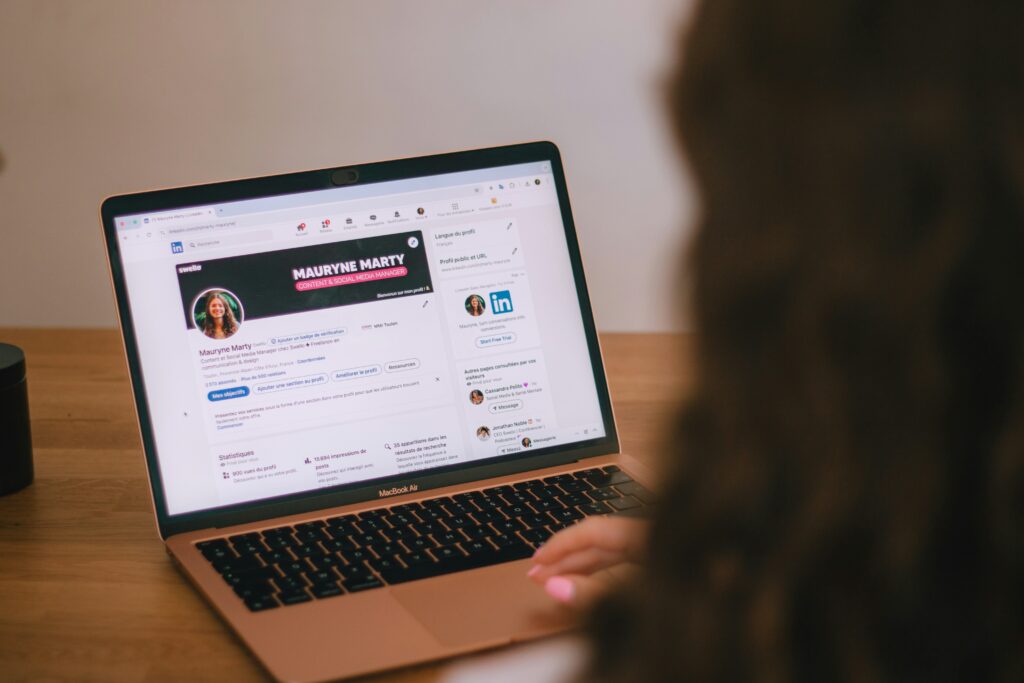 Person checking online profile on laptop — how to verify authenticity of online profiles and spot AI fakes