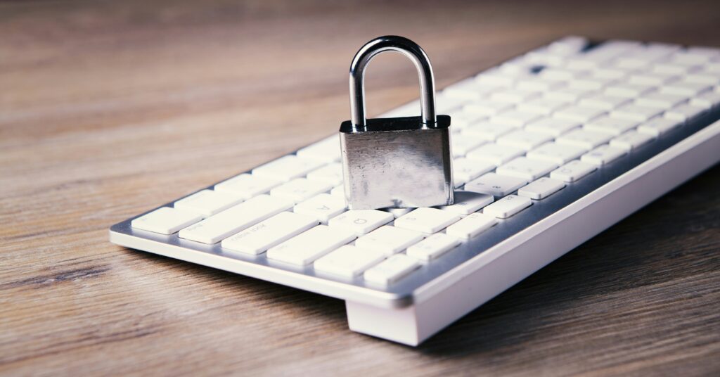 A metal padlock sitting on top of a white computer keyboard, symbolizing online privacy and data security.