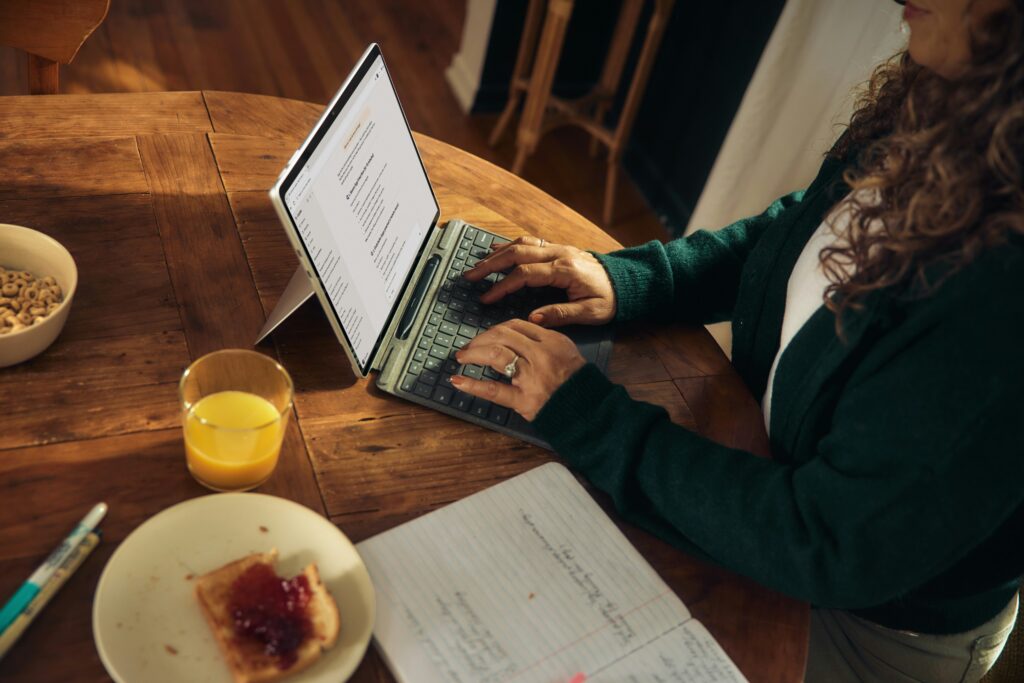 Woman looking someone up online on a tablet while having breakfast at her kitchen table