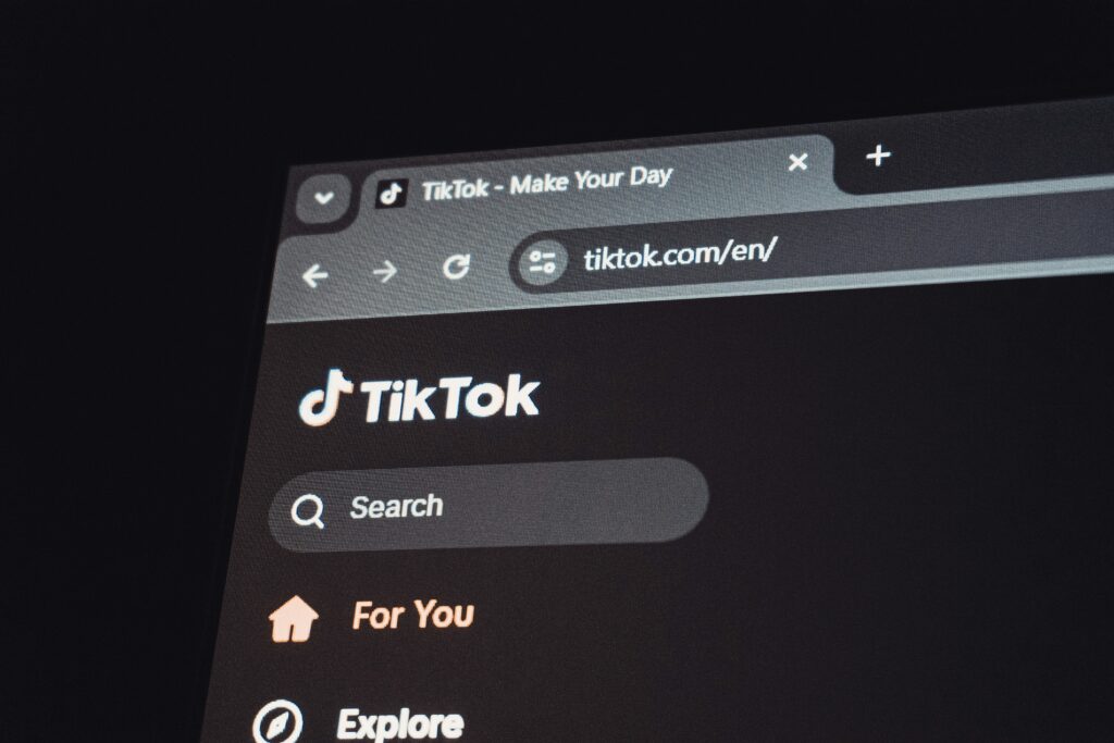 Close-up of a dark-mode browser tab open to TikTok's website, showing the search bar and 'For You' navigation — illustrating how to check a TikTok account's activity from a desktop browser.